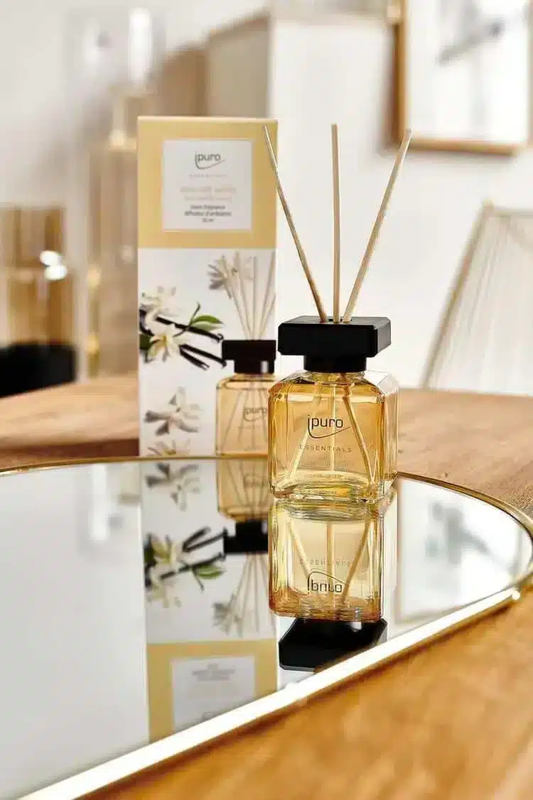 Ipuro Essentials Soft Vanilla geurstokjes in amberkleurig flesje op spiegelplateau met bloemendoos