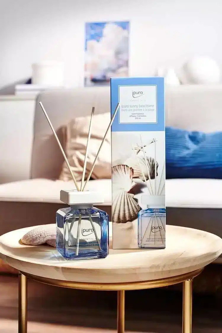 Ipuro Essentials Sunny Beachtime geurstokjes met verpakking op een ronde tafel bij de bank