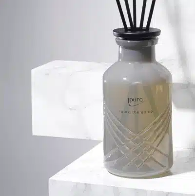 ipuro Exclusive thé épicé reed diffuser 240ml in a grey glass bottle on white marble, close-up